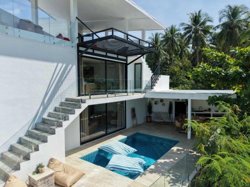 a house with a swimming pool next to a balcony at Luxury manao poolvilla with seaview Koh Lanta in Ko Lanta
