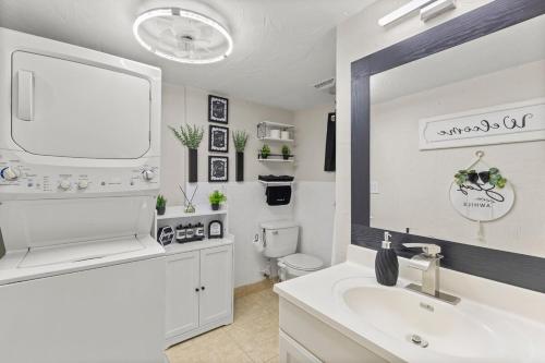 une salle de bain blanche avec un lavabo et un miroir dans l'établissement Casa Tranquila Pool Pergola Spa Shower Retreat, à Venice