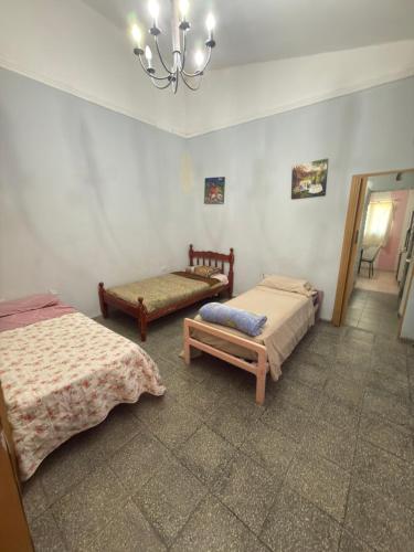 a bedroom with two beds and a chandelier at YBVerde in Yerba Buena