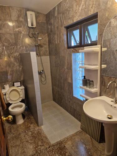 a bathroom with a shower and a toilet and a sink at Lonops Gay Paradise in Nong Prue