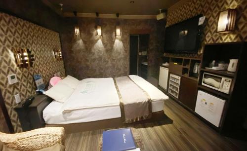 een slaapkamer met een groot bed en een tv bij CURE in Sumino