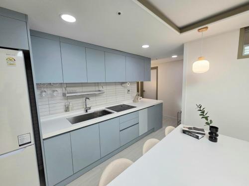 eine Küche mit blauen Schränken und einer weißen Arbeitsplatte in der Unterkunft 2 Bathrooms & 3 Rooms, New Elevator in Seoul