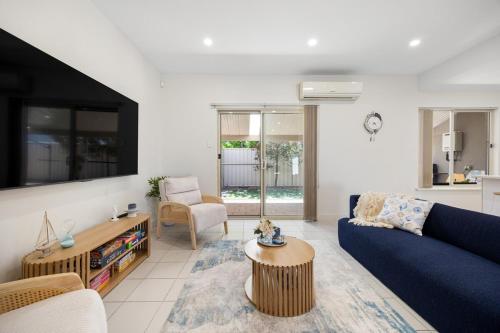 a living room with a blue couch and a table at Aldinga Horizon in Aldinga Beach
