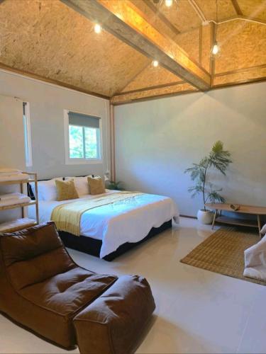 a bedroom with a bed and a chair and a couch at Pradu House Koh Yao Noi in Ko Yao Noi