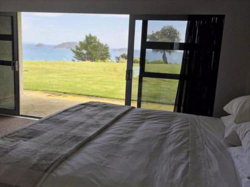 Ce lit se trouve dans un dortoir offrant une vue sur l'océan. dans l'établissement King of the Hill, à Amodeo Bay