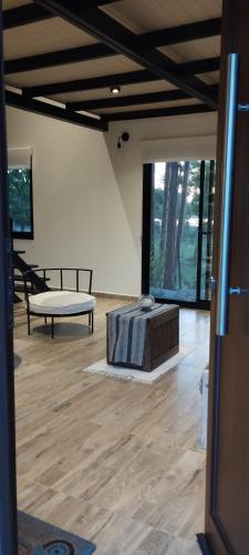 a room with a bed and a bench on a wooden floor at Portal del Lago - Casa confortable cerca del lago - Hermoso atardecer in Federación