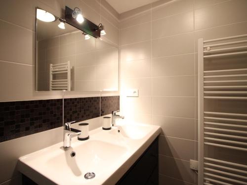 ein Badezimmer mit Waschbecken und Spiegel in der Unterkunft Beau F3 avec parking et animaux acceptés, proche Thermes - FR-1-415-165 in Le Mont-Dore