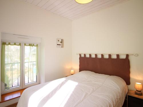 ein Schlafzimmer mit einem großen weißen Bett und einem Fenster in der Unterkunft Appartement 55m² centre Mont-Dore, 2 chambres, parking, animaux admis - FR-1-415-194 in Le Mont-Dore