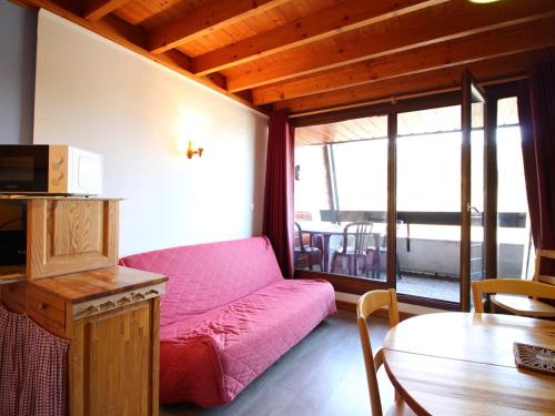 un salon avec un canapé rose et une table dans l'établissement Duplex F2 au Mont-Dore avec Garage Privé - FR-1-415-167, à Mont-Dore