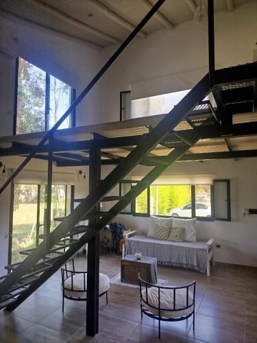 a living room with a staircase in a house at Portal del Lago - Casa confortable cerca del lago - Hermoso atardecer in Federación