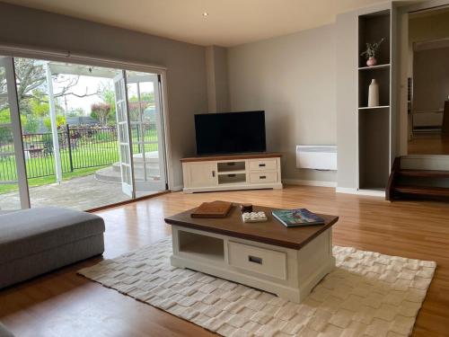 a living room with a tv and a coffee table at Clonburn Manor at Sovereign Hill in Ballarat