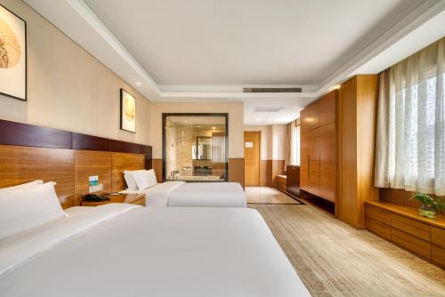 a hotel room with two beds and a bathroom at 青岛机场富华酒店 in Qingdao