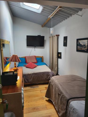 a bedroom with two beds and a flat screen tv at Apartamento 201 completo Chía Norte in Chía