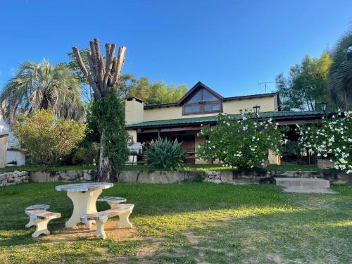 ein Haus mit zwei Bänken davor in der Unterkunft Cabañas Lodge Angirú in Goya