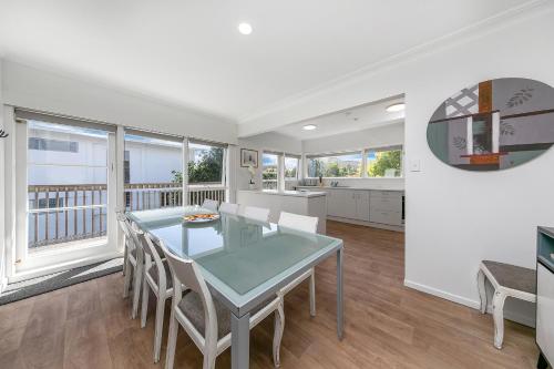 a kitchen and dining room with a table and chairs at Spacious house 5 minutes walk to St Helier Beach in Auckland