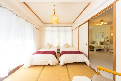 deux lits dans une chambre avec un miroir dans l'établissement Miraie Katano Stay, à Kisabe
