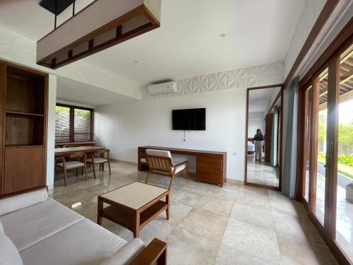 a living room with a couch and a tv on the wall at Medewi Surf Villa Luxury in Airsatang