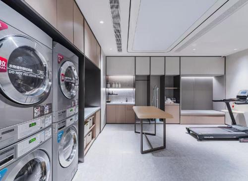 eine Waschküche mit Waschmaschine und Trockner in der Unterkunft JI Hotel Shanghai Meiling North Road Subway Station in Shanghai