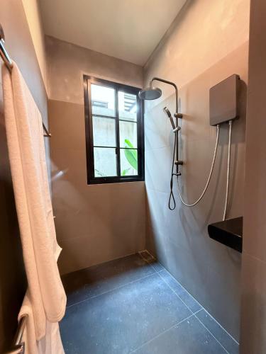 a bathroom with a shower and a window at Sakhu Art Villa in Nai Yang Beach