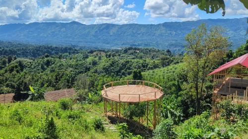 a view of the mountains from a farm with a basketball hoop at Toma Tungi Resort & Restaurant in Bāndarban