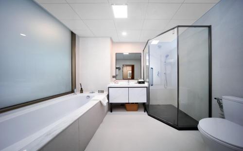 une salle de bain avec une baignoire, un lavabo et des toilettes dans l'établissement Xiamen Weir Hotel, à Gaolin