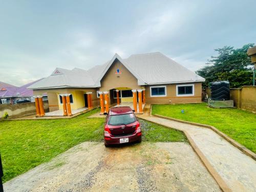 a red car parked in front of a house at AnKeS Lodge in Kontrajeso