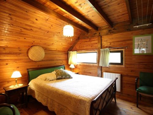 une chambre avec un lit dans une cabane en bois dans l'établissement Chalet au Mont-Dore, 3 chambres, terrasse et parking, 8 couchages - FR-1-415-208, à Mont-Dore