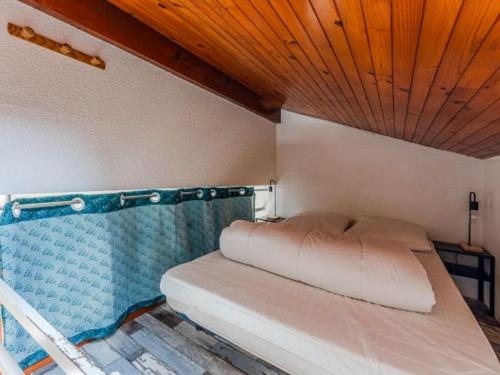 ein Bett in einem Zimmer mit Holzdecke in der Unterkunft Charmant appartement avec mezzanine et parking - 4 pers - FR-1-521-263 in Biscarrosse-Plage