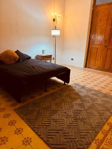 a bedroom with a bed with a rug and a lamp at Lartbook Mty in Monterrey