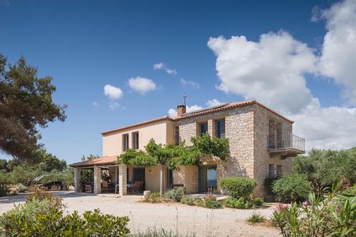 an old stone house with a balcony in front of it at Vrysomylos in Vromonérion