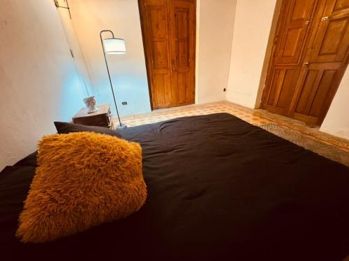 a bedroom with a large black bed with a yellow blanket at Lartbook Mty in Monterrey