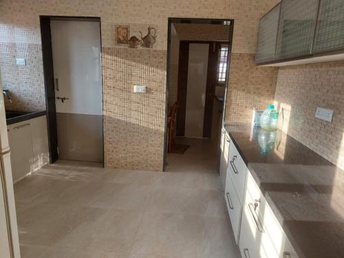 a kitchen with white cabinets and a counter top at Nidha Home in Ooty