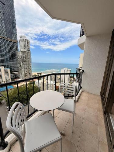 un balcon avec une table et des chaises et l'océan dans l'établissement Ocean-view hotel room on Level 17 in central Surfers Paradise, à Gold Coast