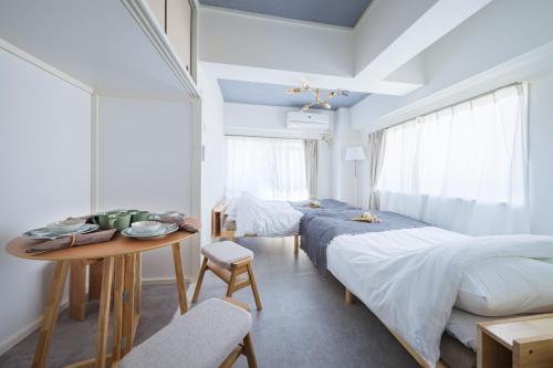 a bedroom with two beds and a table and a table at Comfy Stay Tokiwadai 2minute walk from Tokiwadai Station Ikebukuro 9min Shinjuku 14min Shibuya 18min Max 4guests Many restaurants nearby hot spring Shrine nearby in Tokyo