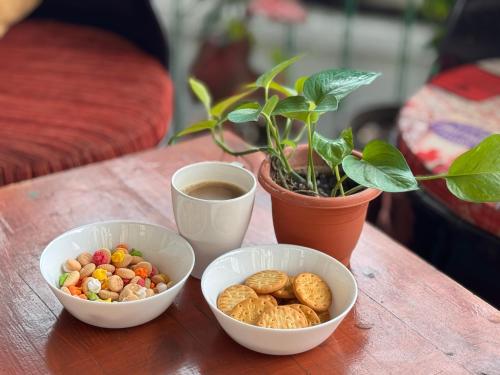 a table with three bowls of snacks and a cup of coffee at Attic Hotel in George Town