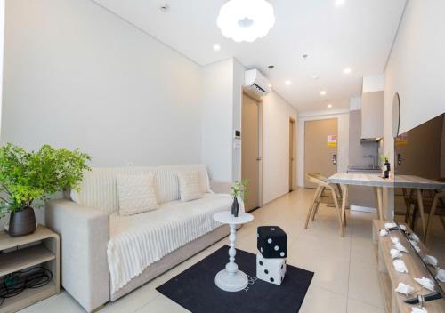 头顿The Song Boutique Aparment - Căn hộ Anh Kiet Home的客厅里有一张白色的沙发和一张桌子