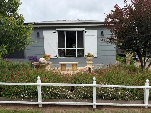 a white fence in front of a house at Cozy Cottage Victor Harbor in Hindmarsh Valley