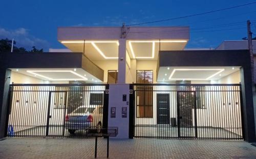 a house with a gate and a car in front of it at Cataratas Paradise - O seu conforto na natureza! in Foz do Iguaçu