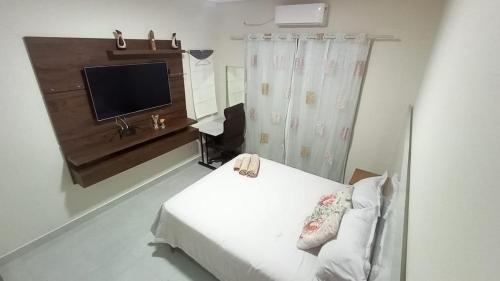 a bedroom with a bed and a tv and a couch at Cataratas Paradise - O seu conforto na natureza! in Foz do Iguaçu