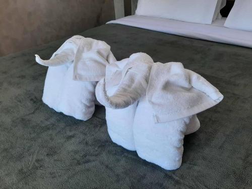 Zwei Handtücher, Stoffelefanten sitzen auf einem Bett in der Unterkunft Momems House in Ban Tha Pai