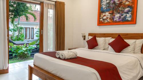 a bedroom with two beds and a large window at Adi Abian Uluwatu by Tanya Pink in Uluwatu