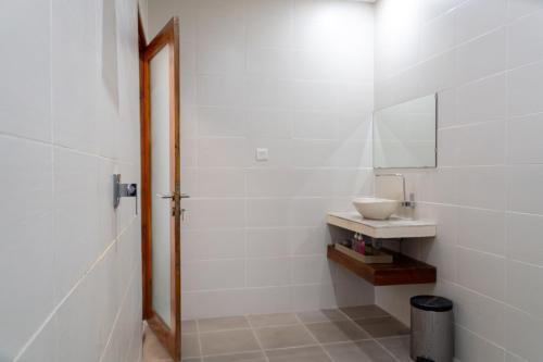 a bathroom with a sink and a mirror at Adi Abian Uluwatu by Tanya Pink in Uluwatu