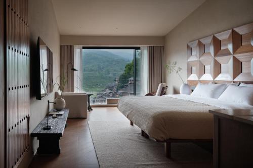 a bedroom with a large bed and a large window at See the mountains, find the place to stay in Xijiang