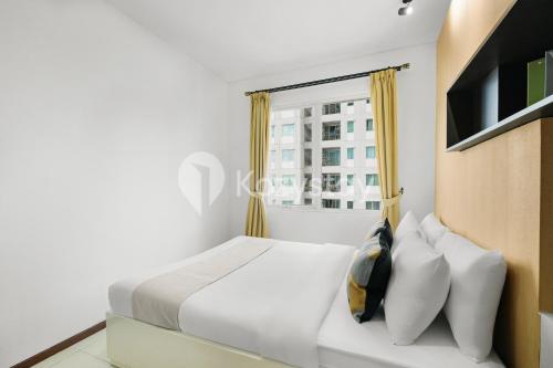 a bedroom with a white bed and a window at Javen by Kozystay - Thamrin in Jakarta