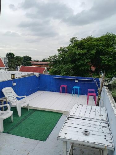 a patio with chairs and a table on a roof at Sleepwith me Hostel in Bangkok