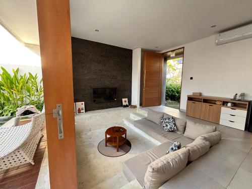 a living room with a couch and a fireplace at Casa Gemellia Brand New 2BR in Umalas in Kerobokan
