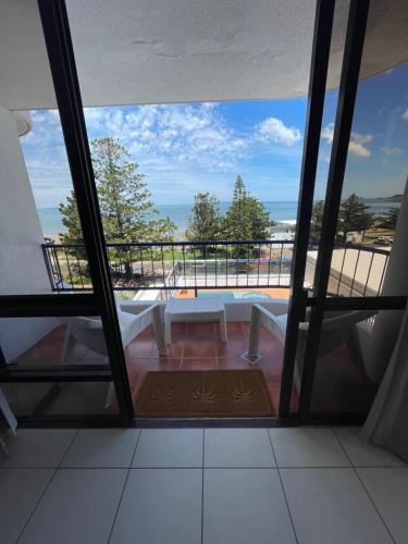 a room with a table and a view of the ocean at Heart of Yeppoon - Ocean View Apartment in Yeppoon