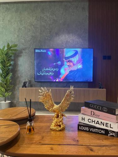 a table with a bird statue on a table with books at نزل Rest in Hail