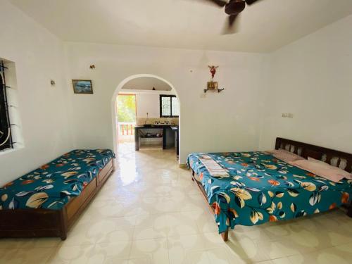 a bedroom with two beds and a desk in it at Sunflake Stays in Agonda