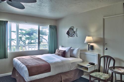 pokój hotelowy z łóżkiem i oknem w obiekcie Lovers Point Inn w mieście Pacific Grove